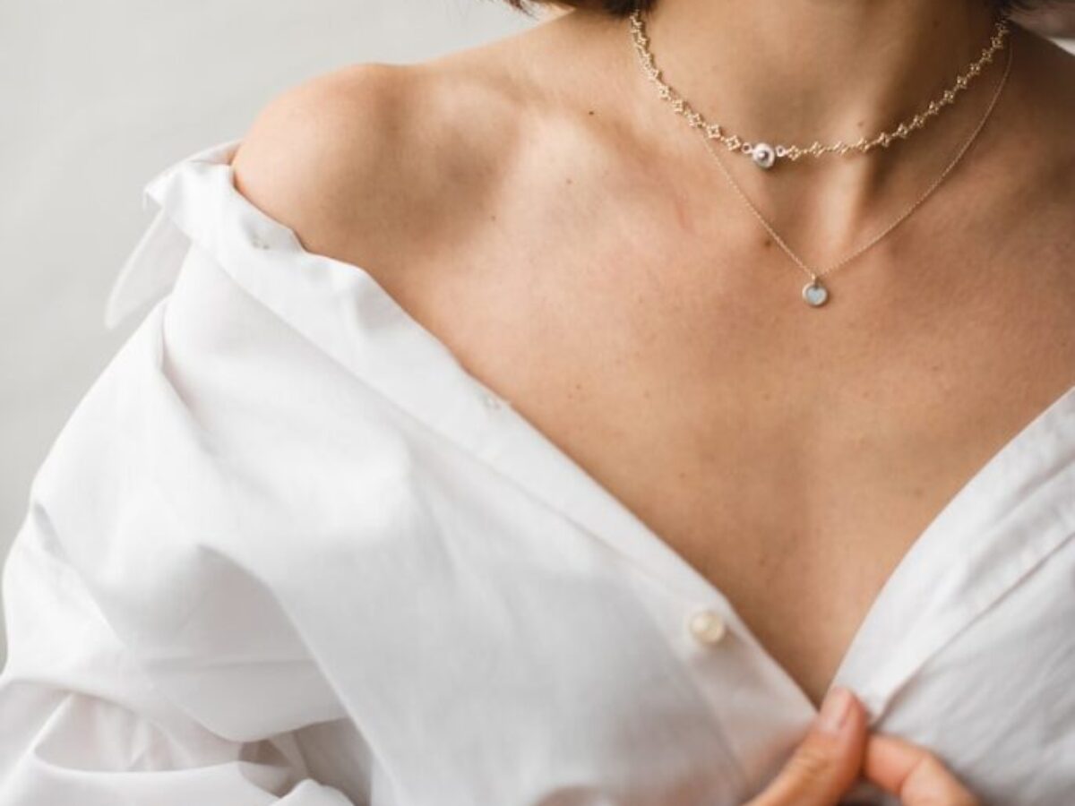 woman in white dress shirt wearing silver necklace
