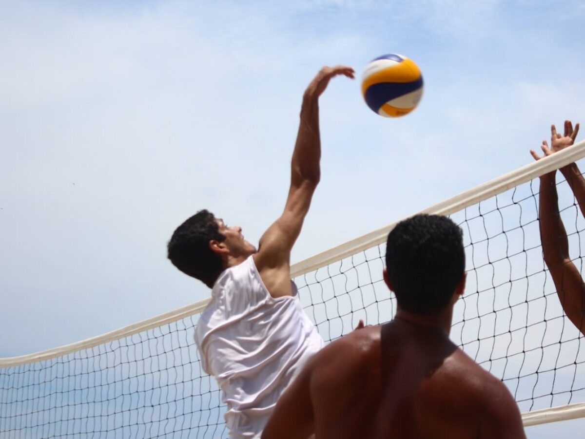 man in white shorts playing volleyball during daytime