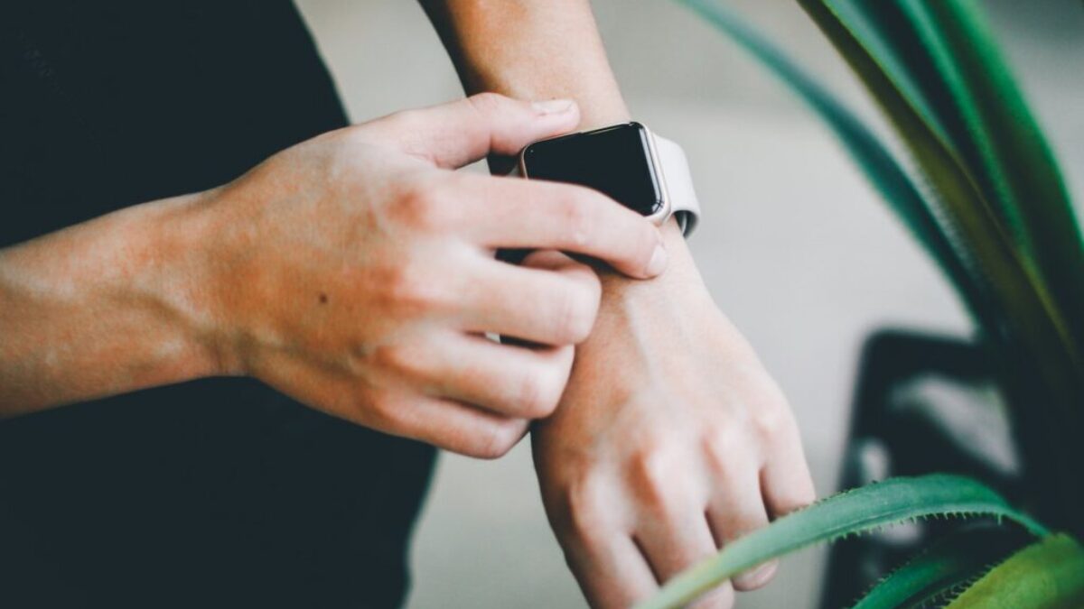 person about to use silver Apple Watch in grey Sports Band