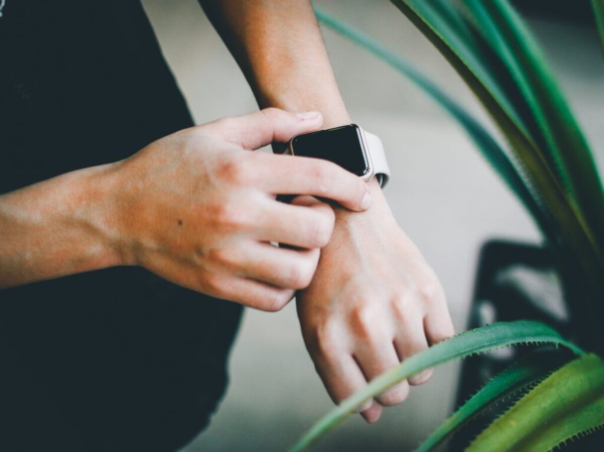person about to use silver Apple Watch in grey Sports Band