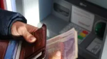 person holding brown leather wallet and banknotes