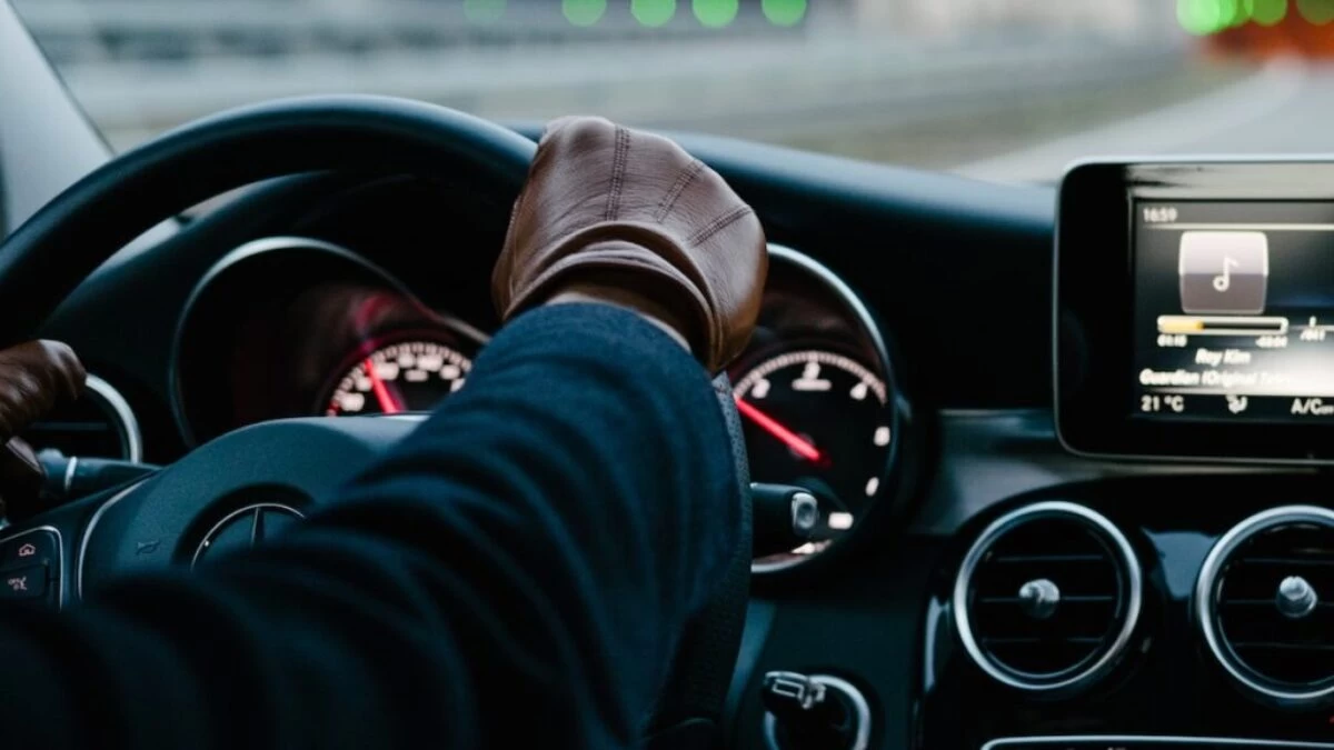 person inside vehicle holding steering wheel