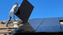 man in white dress shirt and blue denim jeans sitting on white and black solar panel