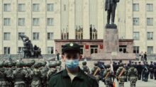 soldiers in black uniform standing near gray concrete building during daytime