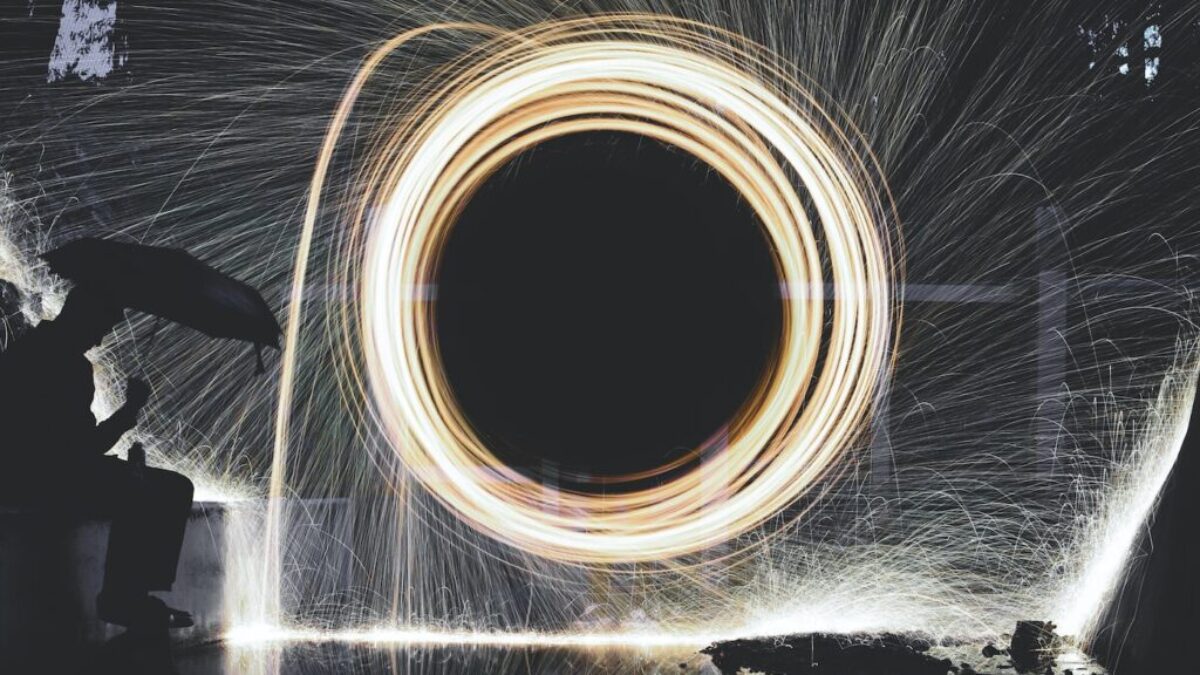 photo of person holding umbrella near steelwool during nighttime