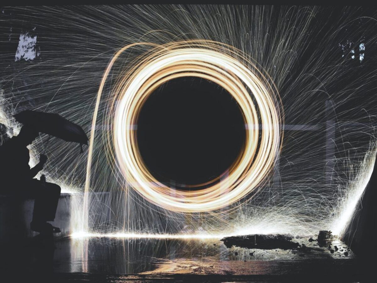 photo of person holding umbrella near steelwool during nighttime