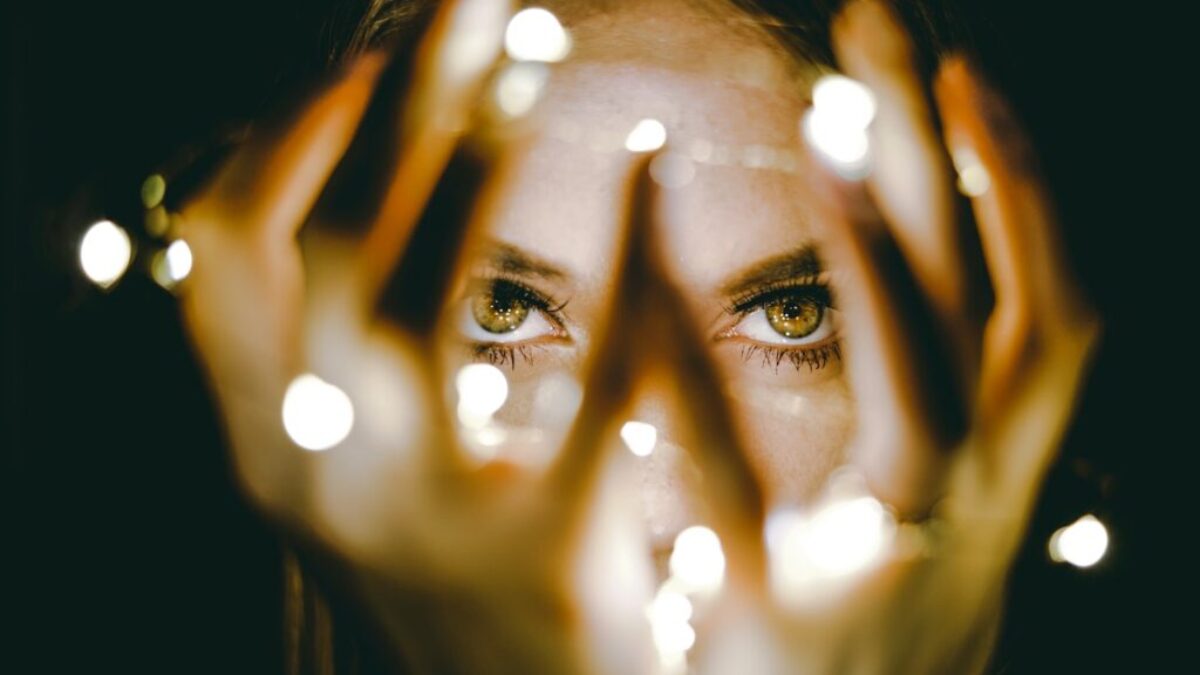 woman holding string lights