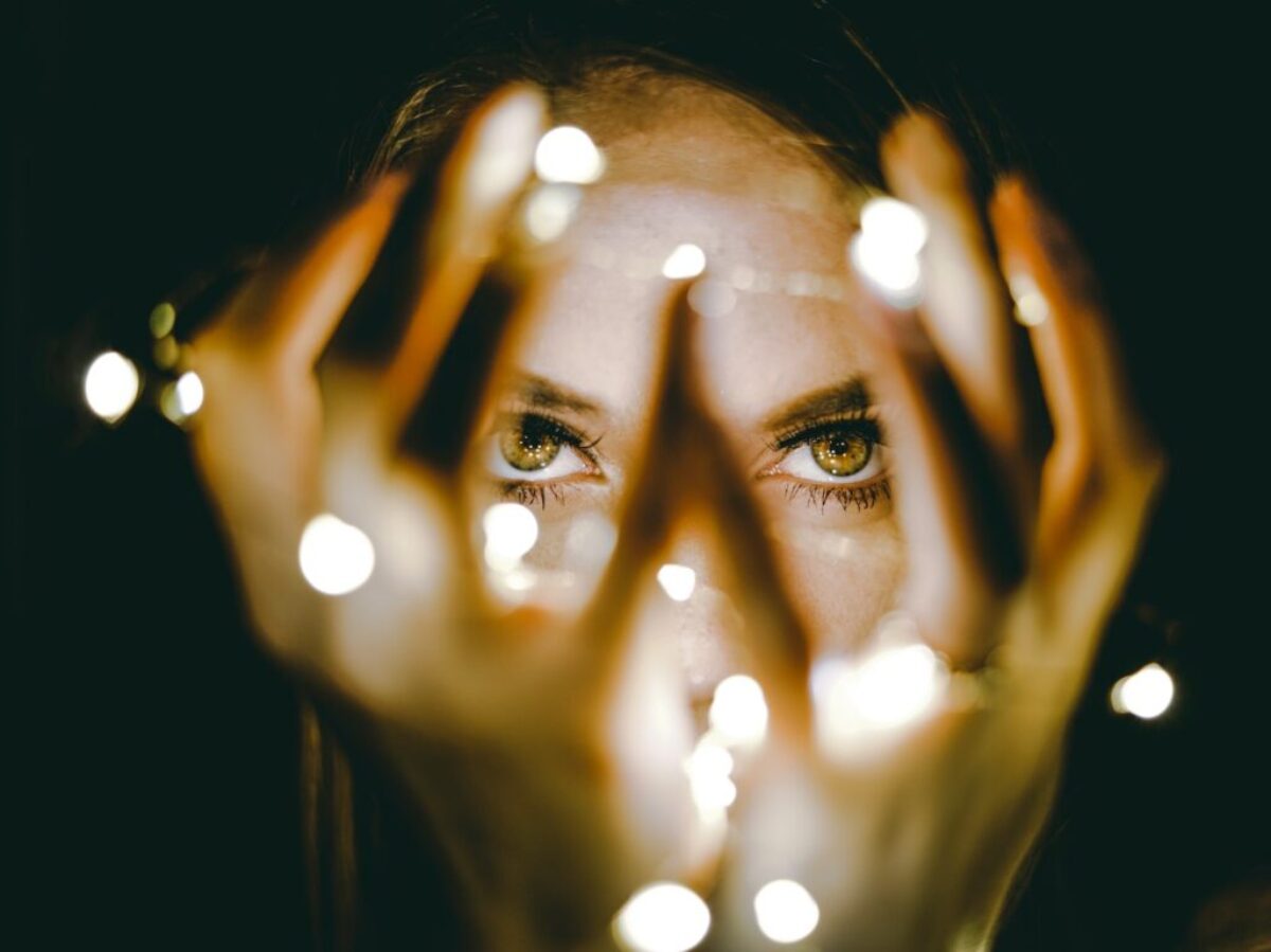 woman holding string lights