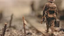 soldier walking on wooden pathway surrounded with barbwire selective focus photography