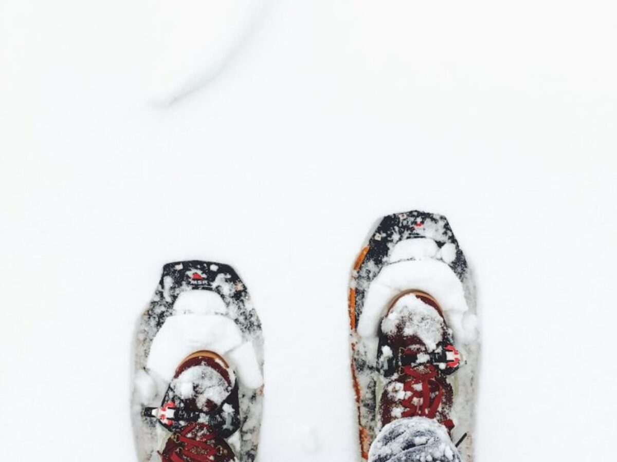 person wearing blue jeans standing on snow