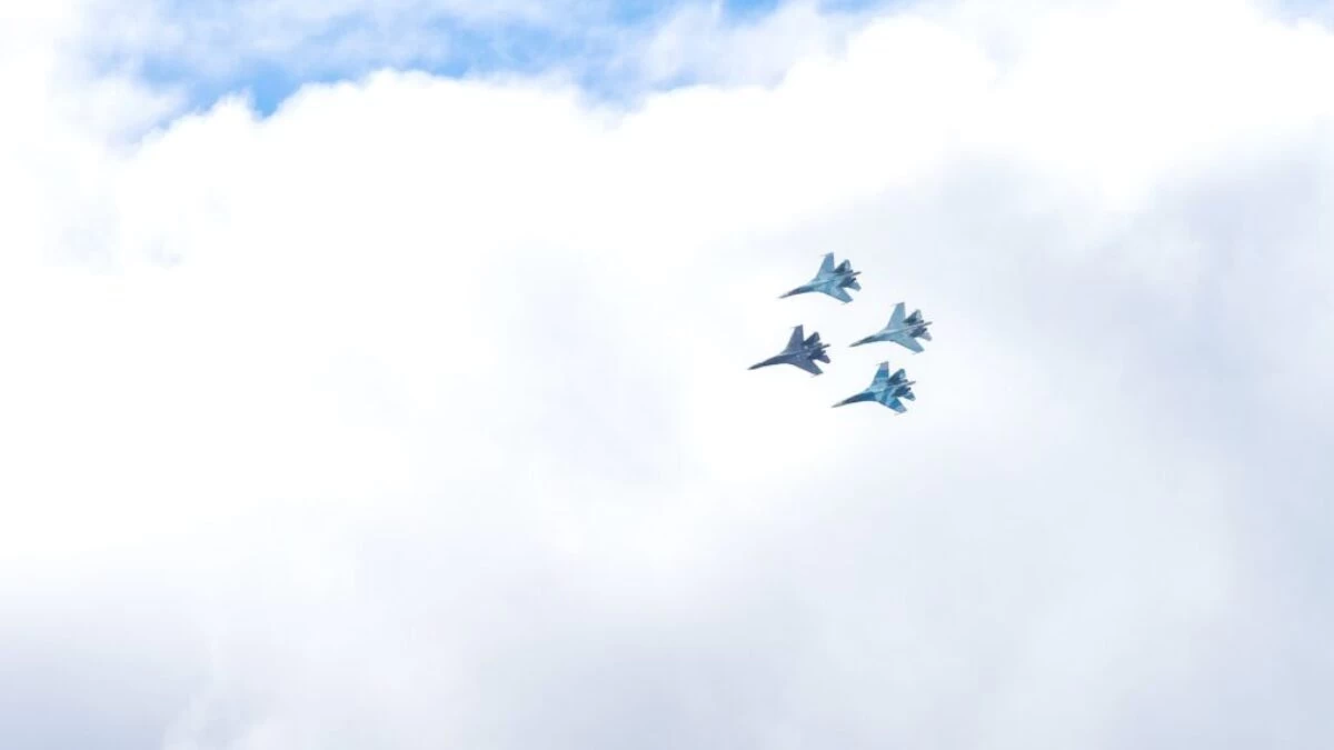 four blue fighting planes surrounded white clouds