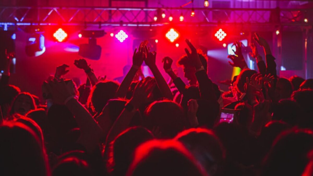 people standing on stage with lights turned on during nighttime