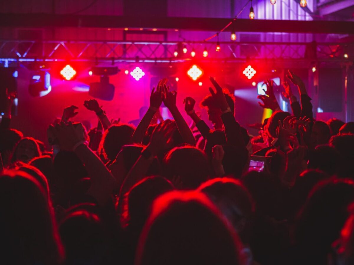 people standing on stage with lights turned on during nighttime