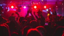people standing on stage with lights turned on during nighttime