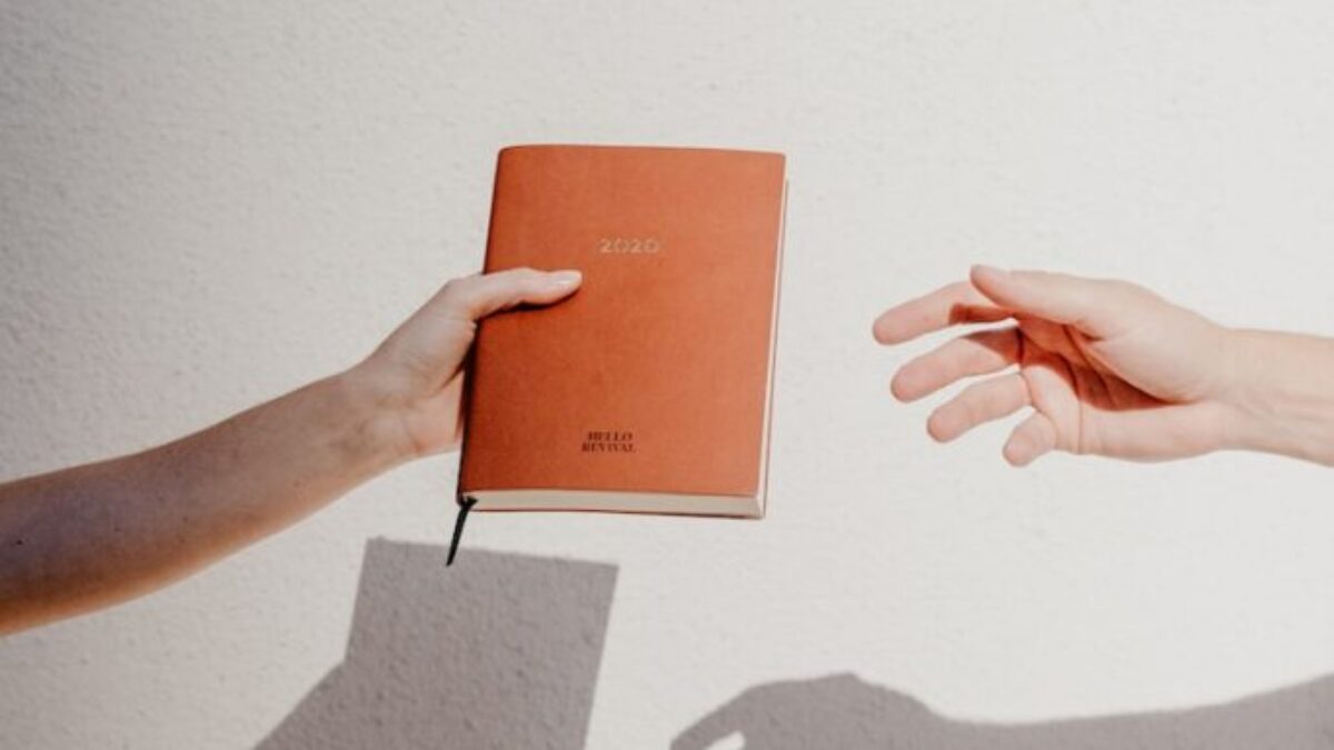 person holding orange book