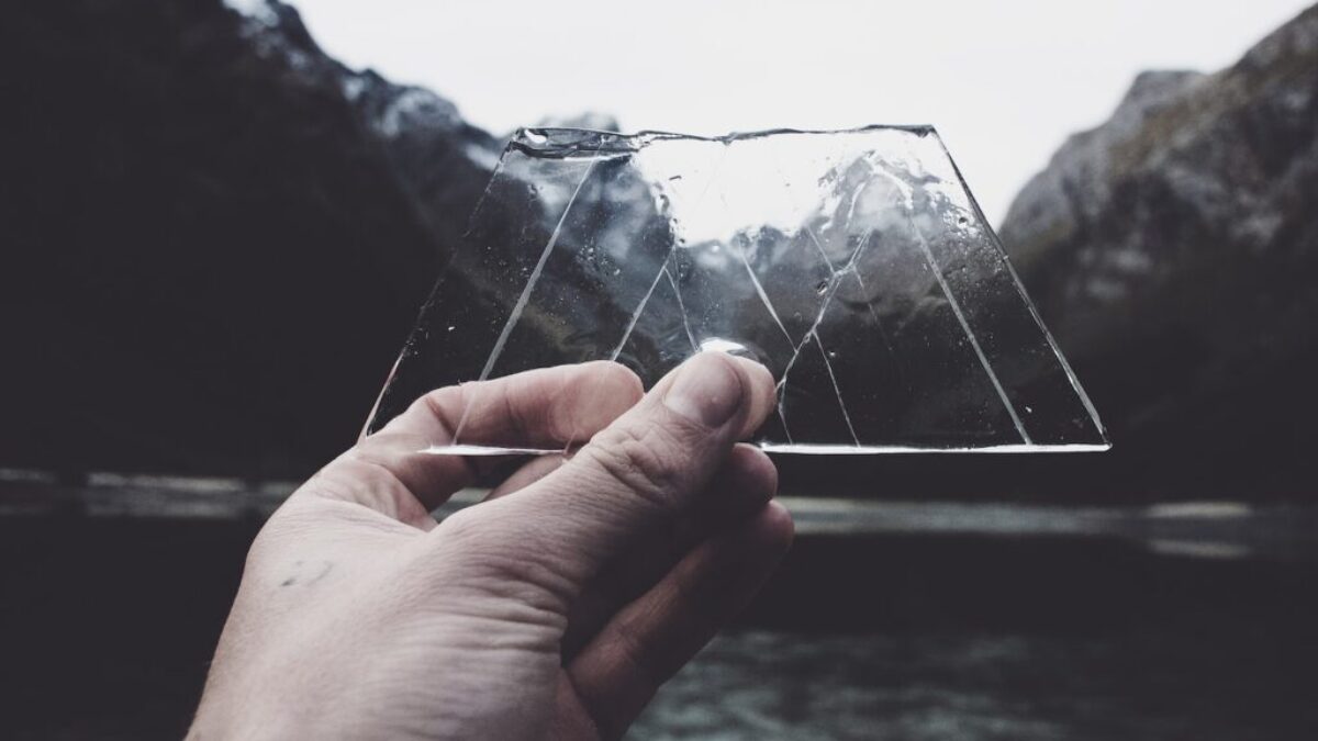 person holding clear glass panel