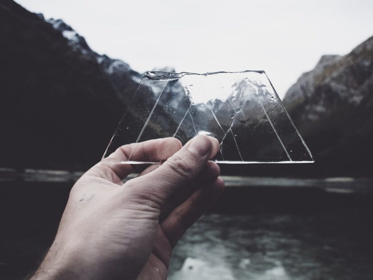 person holding clear glass panel