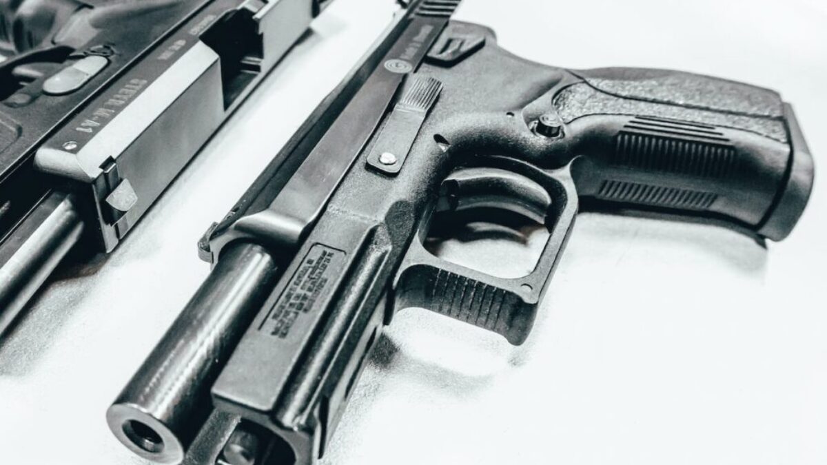 black semi automatic airsoft pistol on white textile