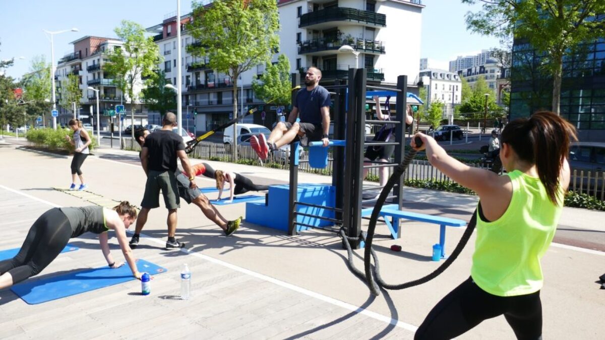 people sitting on blue plastic chairs near black metal post during daytime