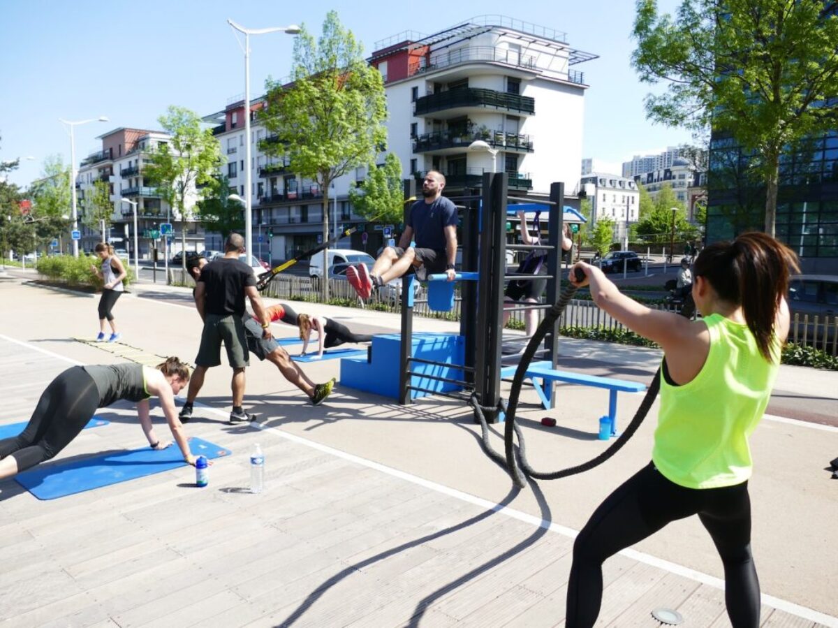 people sitting on blue plastic chairs near black metal post during daytime
