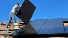 man in white dress shirt and blue denim jeans sitting on white and black solar panel