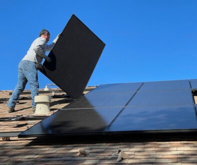 man in white dress shirt and blue denim jeans sitting on white and black solar panel