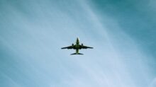 white airplane flying under blue sky