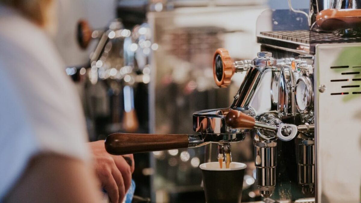 person pouring coffee on black ceramic mug