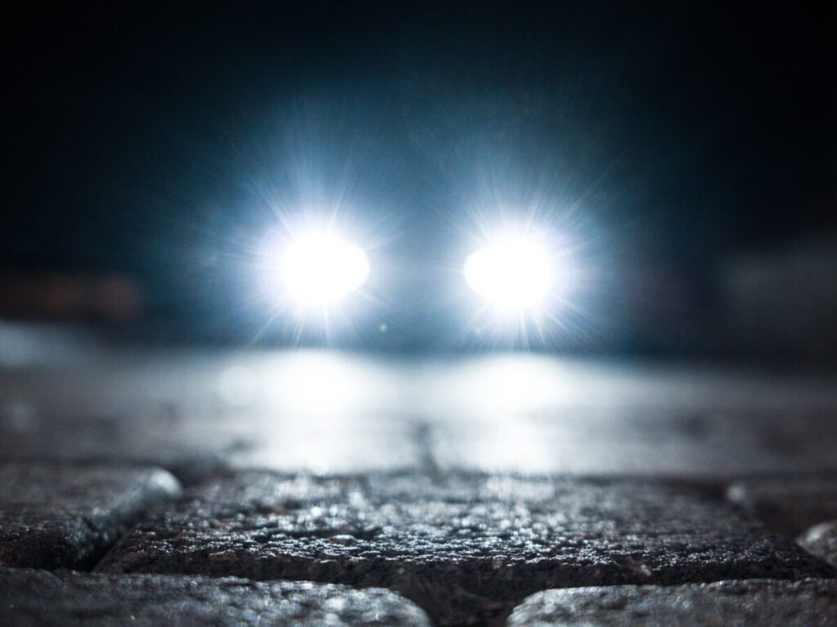 turned-on vehicle headlight on the street