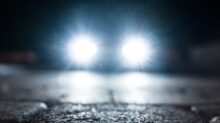 turned-on vehicle headlight on the street