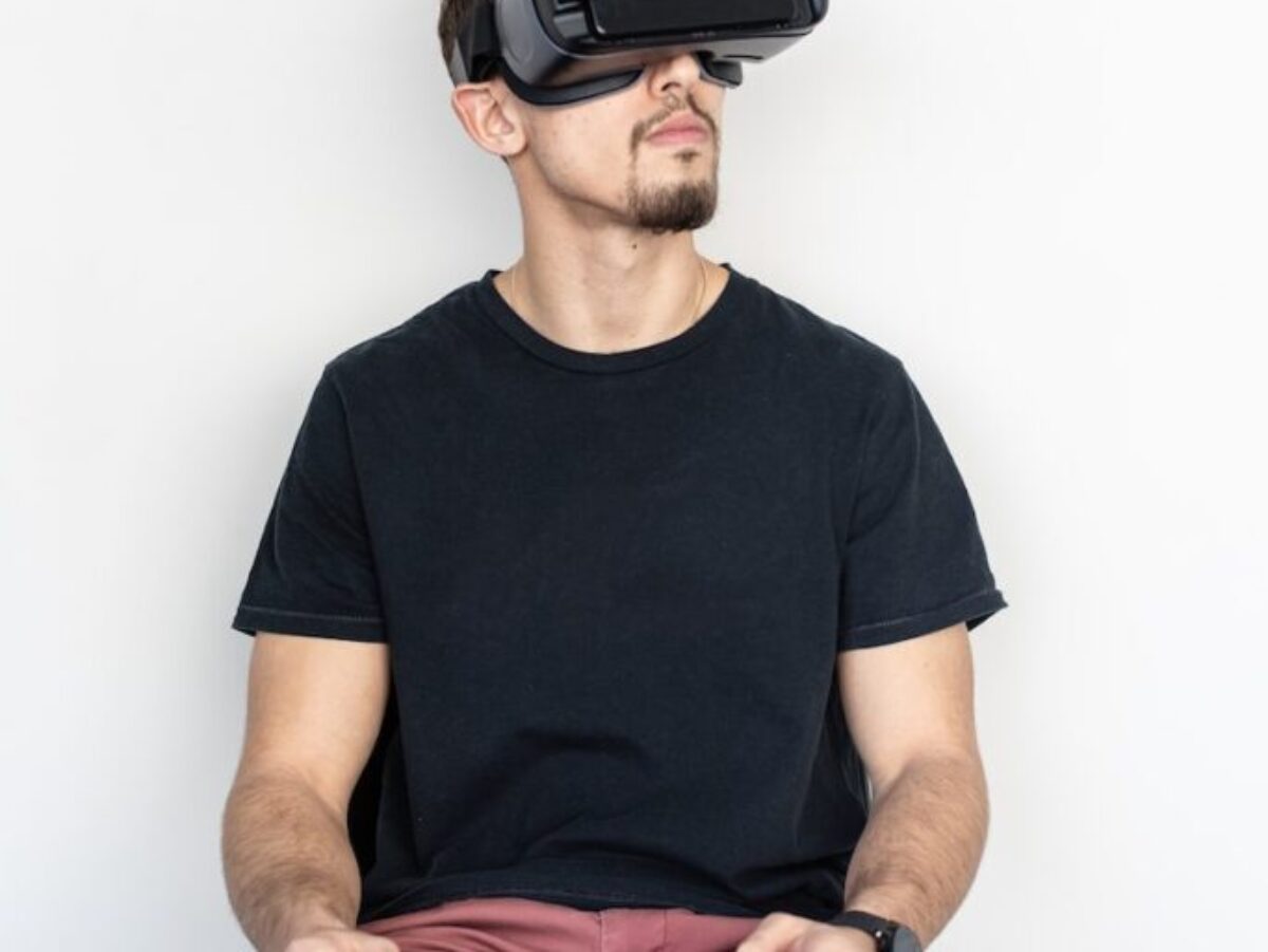 man sitting and using black virtual reality headset