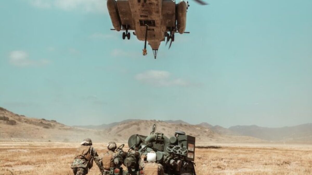 black and brown helicopter flying over brown field during daytime