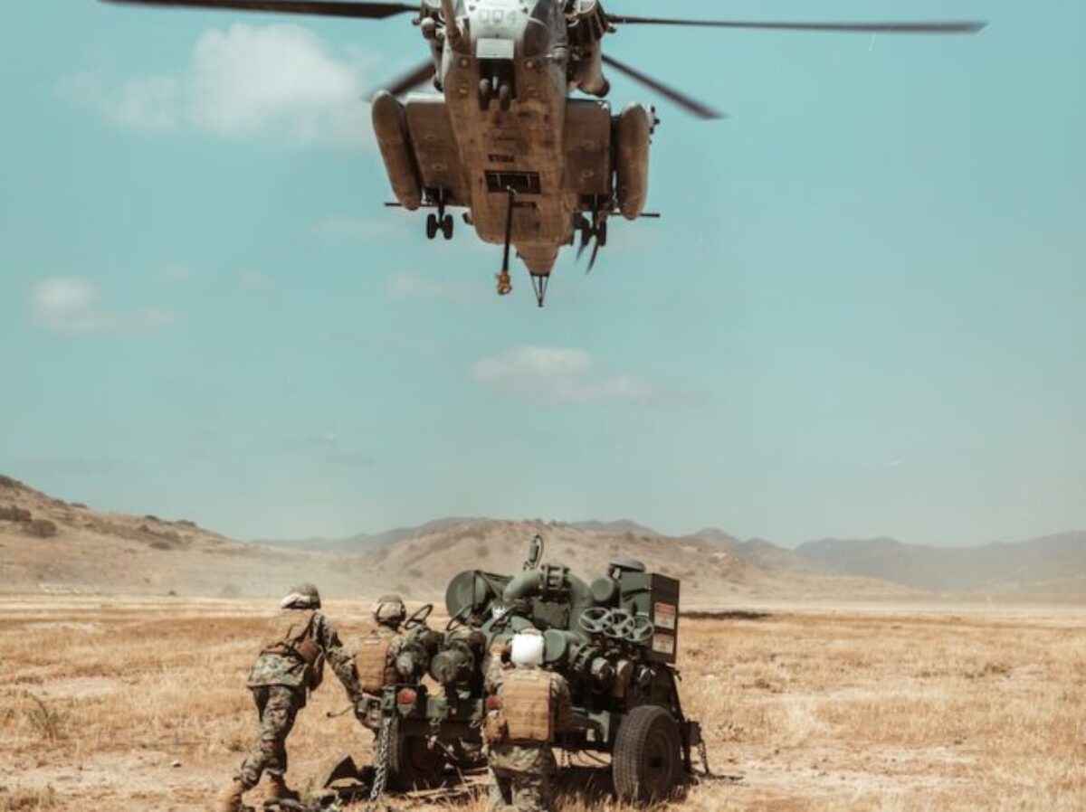black and brown helicopter flying over brown field during daytime