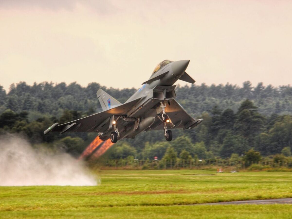 black jet plane on green grass field during daytime