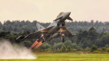 black jet plane on green grass field during daytime
