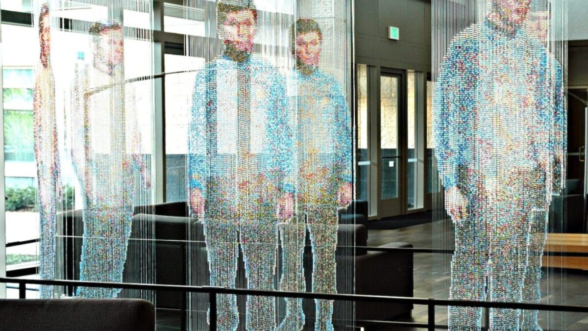 man in white and blue long sleeve shirt standing near glass window