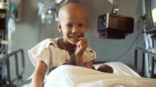 child sitting on bed