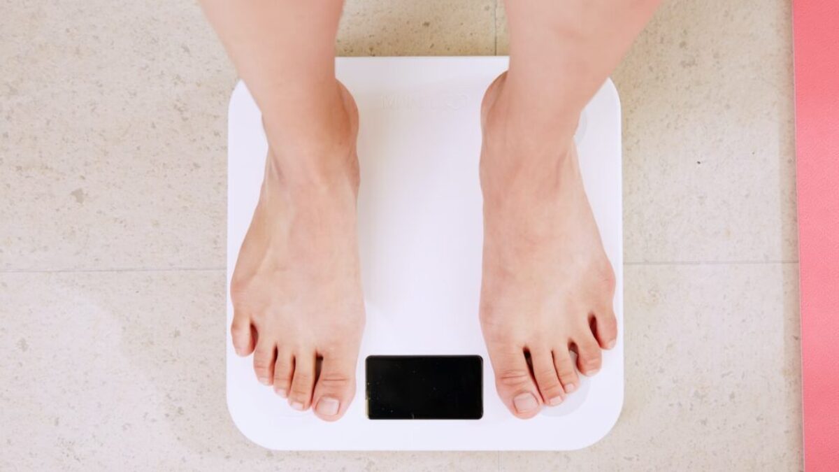 person standing on white digital bathroom scale