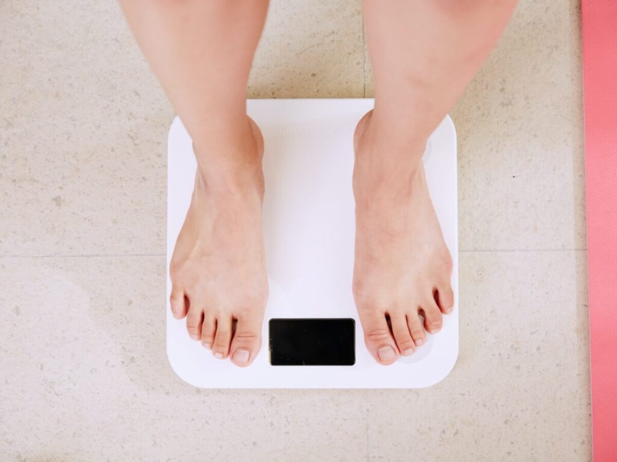 person standing on white digital bathroom scale