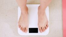 person standing on white digital bathroom scale