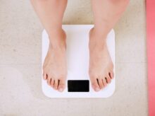person standing on white digital bathroom scale