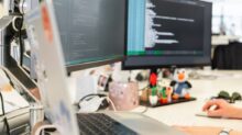 woman in green shirt sitting in front of computer