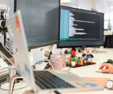 woman in green shirt sitting in front of computer