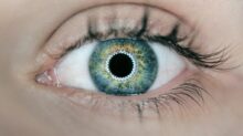 person showing green and black eyelid closeup photography