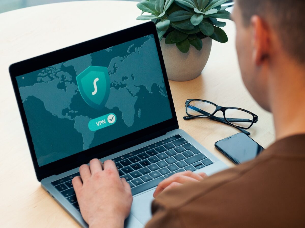 person using macbook pro on white table