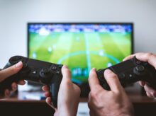 two people playing Sony PS4 game console
