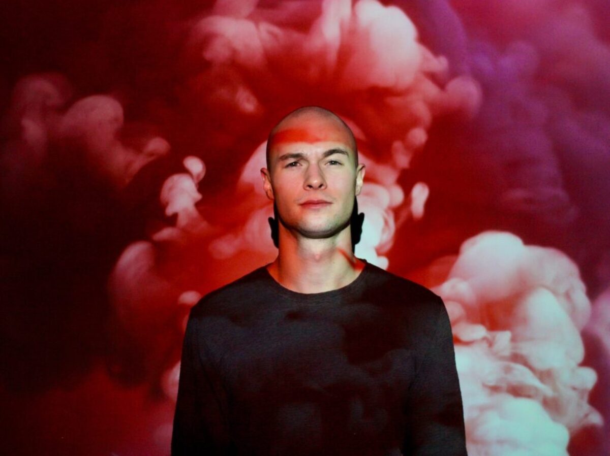 man in black shirt beside pink wall