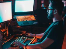 man in blue shirt using computer