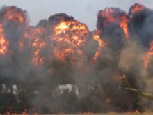green helicopter near big fire