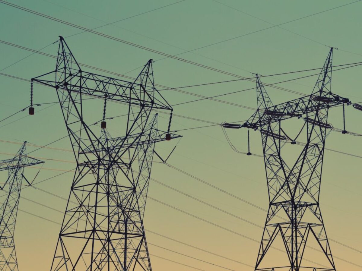 black transmission towers under green sky